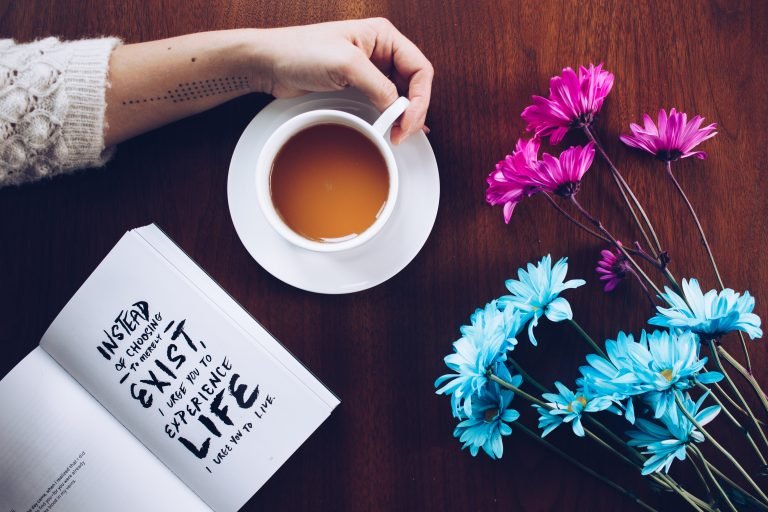 hand with tea cup and journal