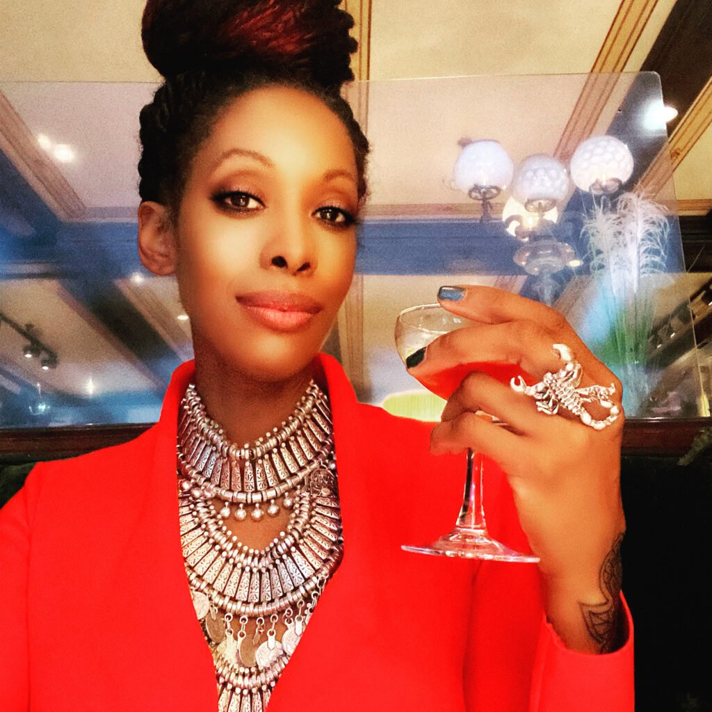 African american woman wearing a red dress while holding a cocktail