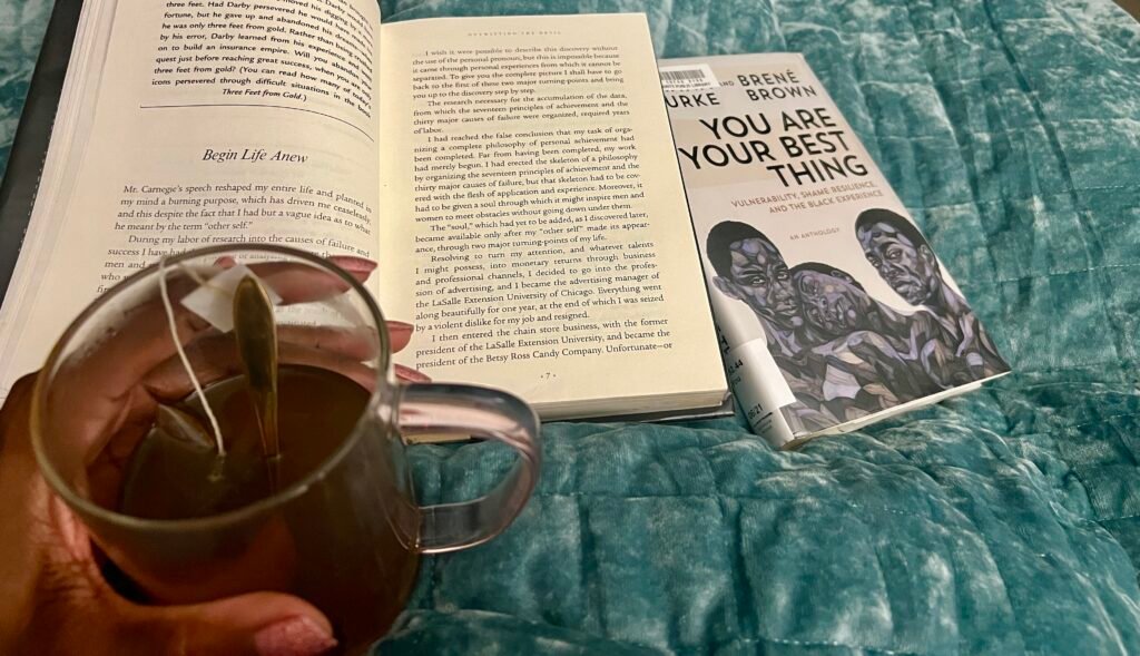photo of books and a hand holding a cup of tea