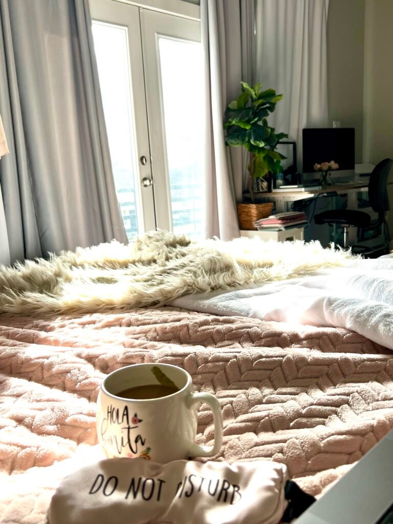 photo of a morning sun drenched bed and a cup of coffee