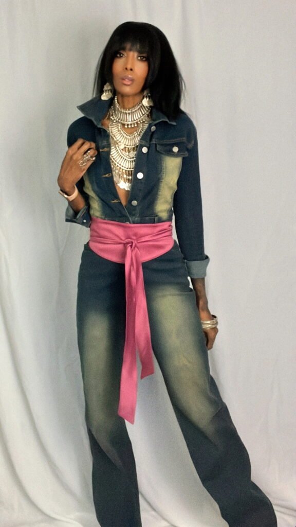 Woman in a jumpsuit with a pink belt and silver statement necklace