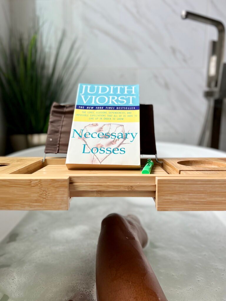 photo of woman in tub reading the book Necessary Losses