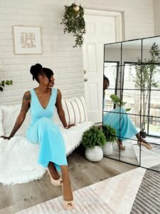 A woman sitting on a couch staring at herself in a mirror think to herself "at least"