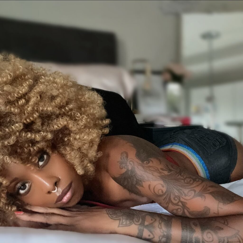 a woman laying on a bed facing the camera as she contemplates change