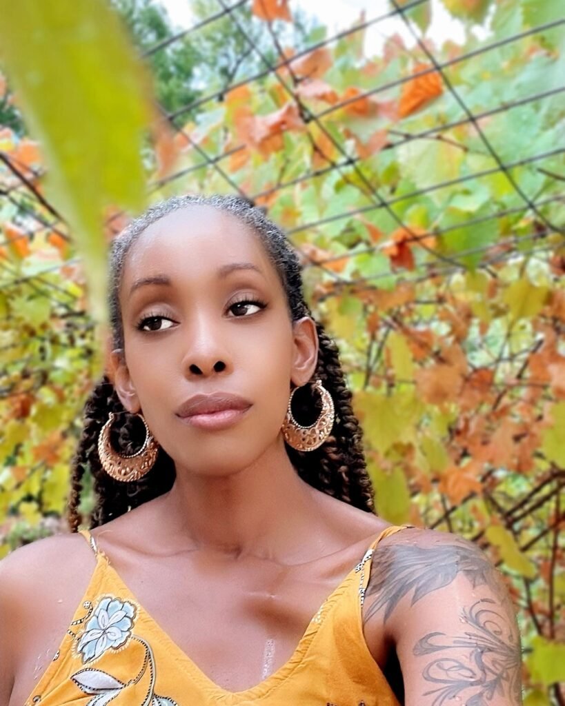 woman standing under grapvines in the rain